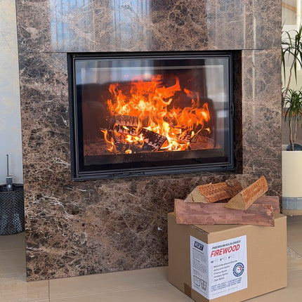 Marble fireplace with a fire burning inside, a kiln dried firewood cardboard box on the floor